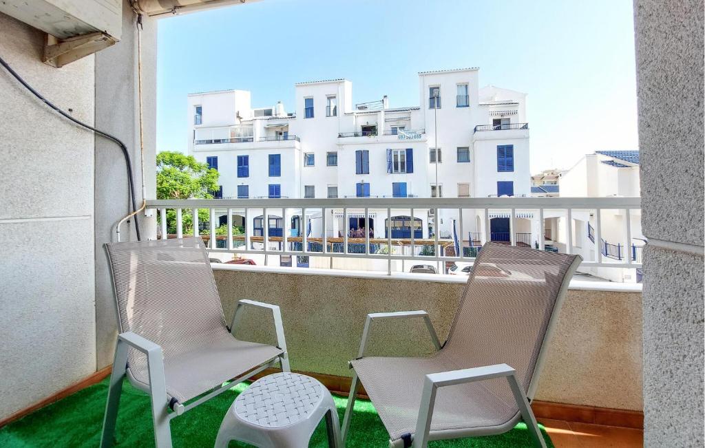 two chairs sitting on a balcony with a building at Beautiful Apartment In Canet De Berenguer in Canet de Berenguer