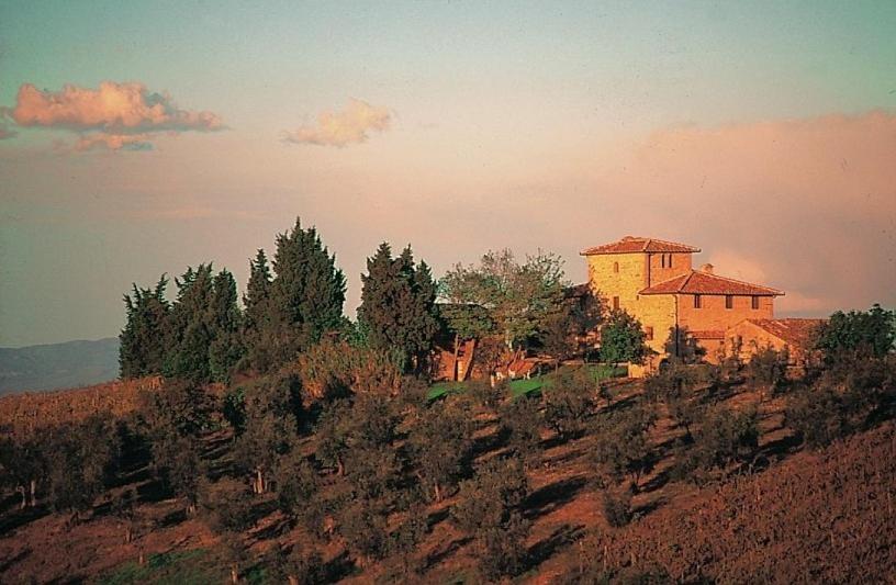 ein Gebäude auf einem Hügel mit Bäumen in der Unterkunft Archipettoli in San Casciano in Val di Pesa