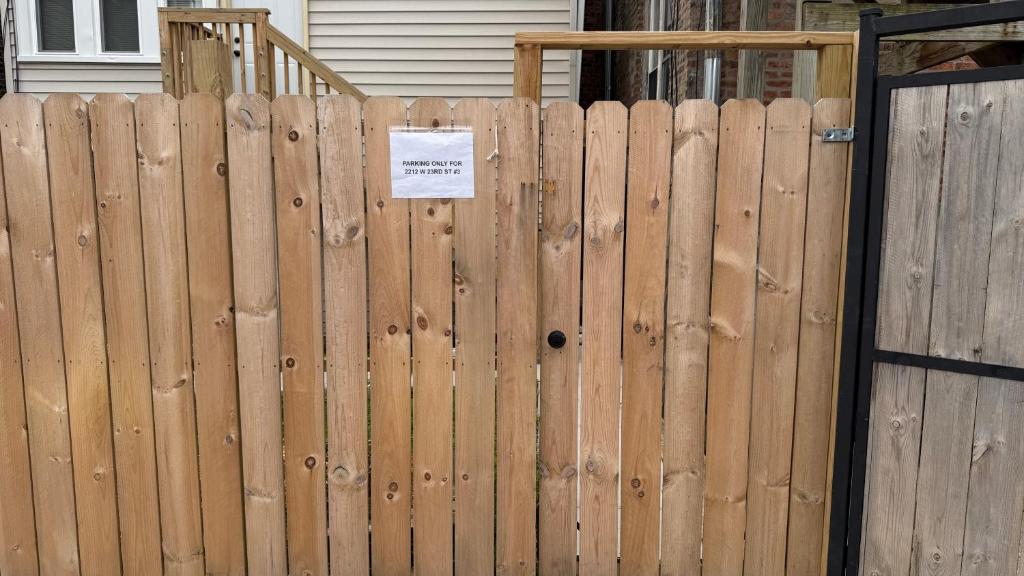 une clôture en bois munie d'un panneau. dans l'établissement Modern Pilsen Chicago Apartment 2 bedroom, à Chicago
