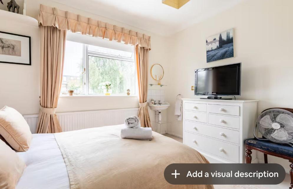a bedroom with a bed and a tv and a window at Double bedroom in homely, 5 bedroom family house by the river in Fulham in London
