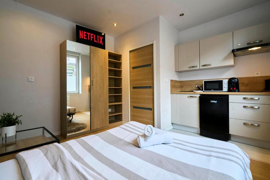 une chambre avec un grand lit et une cuisine dans l'établissement Charmant studio proche de la Gare Lille Flandres, à Lille