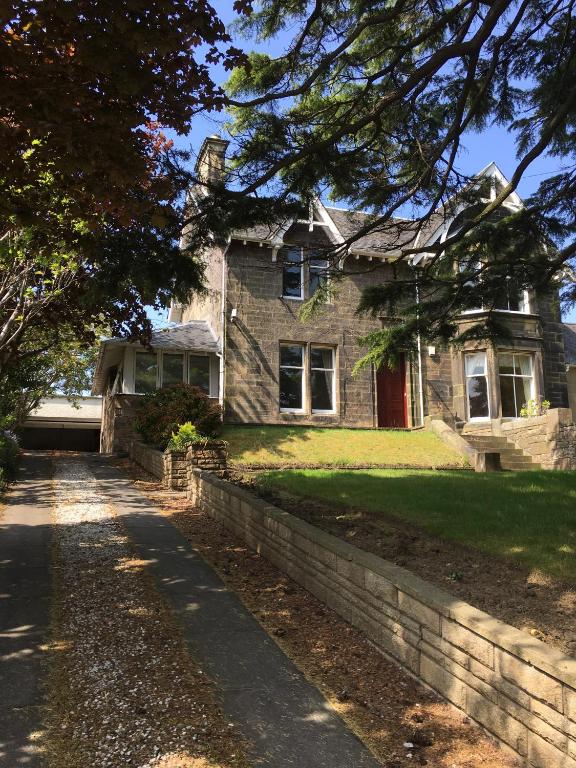 a brick house with a sidewalk in front of it at Lanark Residence in Edinburgh