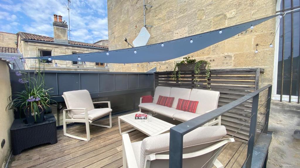 un patio avec deux chaises et une table sur un balcon dans l'établissement Appartements de charme au cœur de Bordeaux avec climatisation et rooftop, à Bordeaux