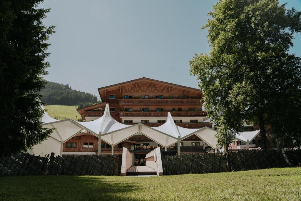un grande edificio con tende bianche di fronte ad esso di Hotel Glemmtalerhof a Saalbach Hinterglemm