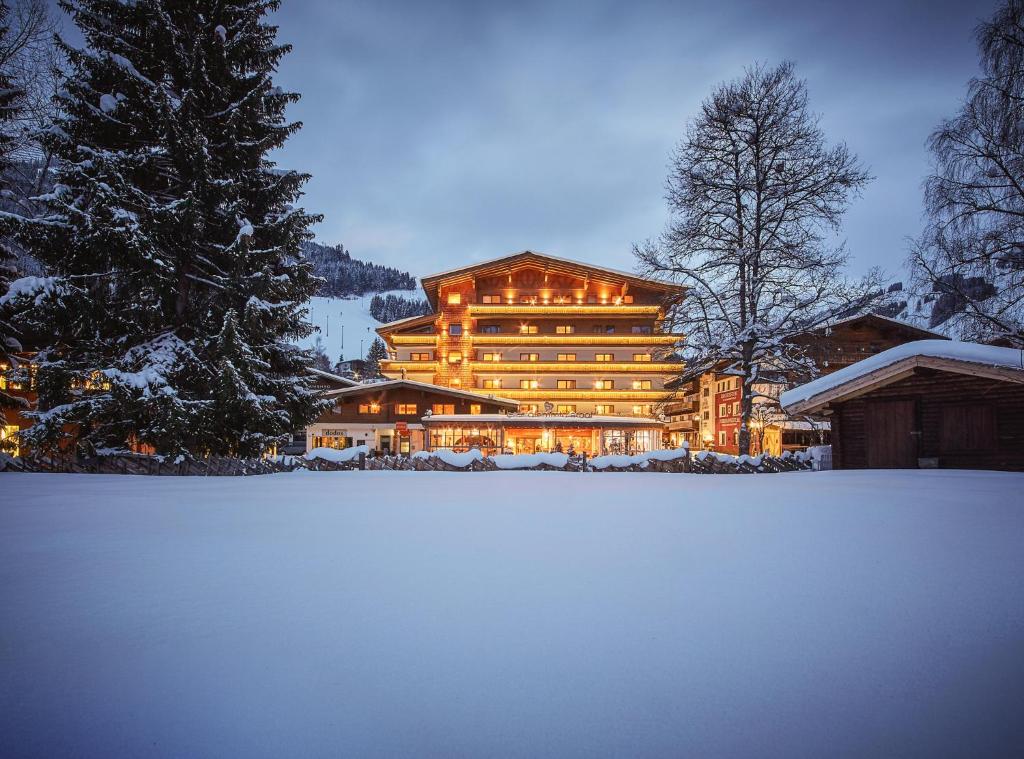 a large building with snow in front of it at Hotel Glemmtalerhof in Saalbach Hinterglemm
