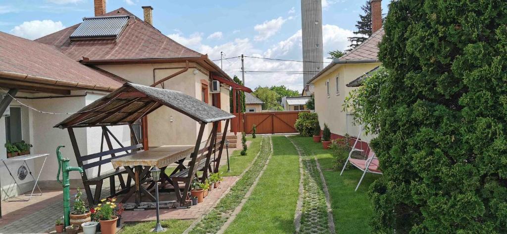 un patio trasero con mesa de picnic y cenador en Rozika Apartman I, en Hajdúszoboszló
