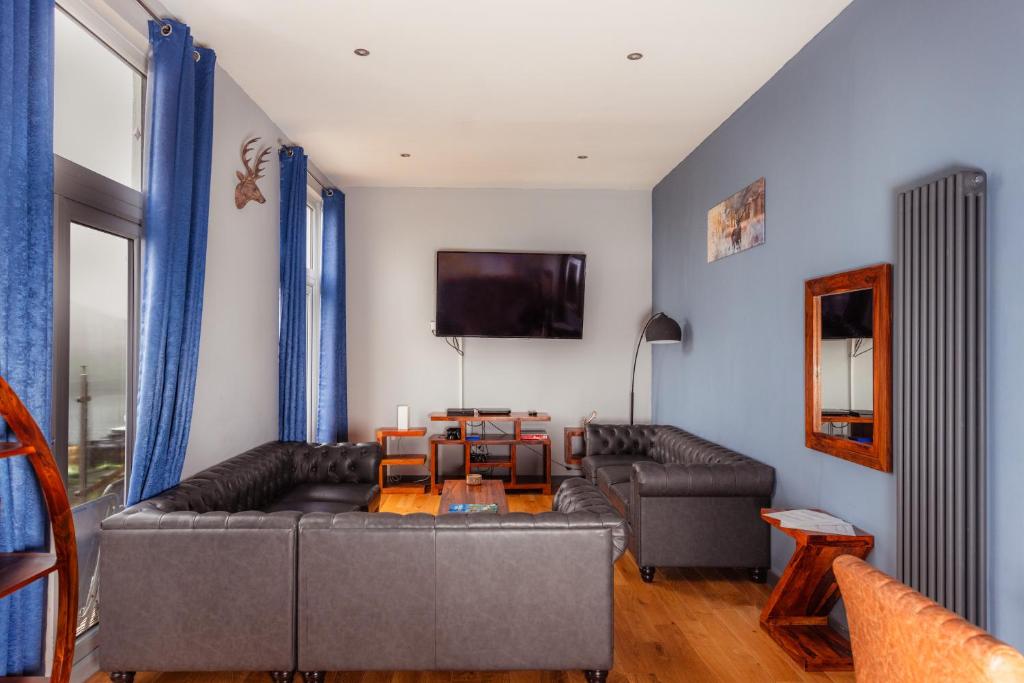 a living room with a couch and a table at Luxury Seaview Cottage by Fairy Pools 2 in Carbost