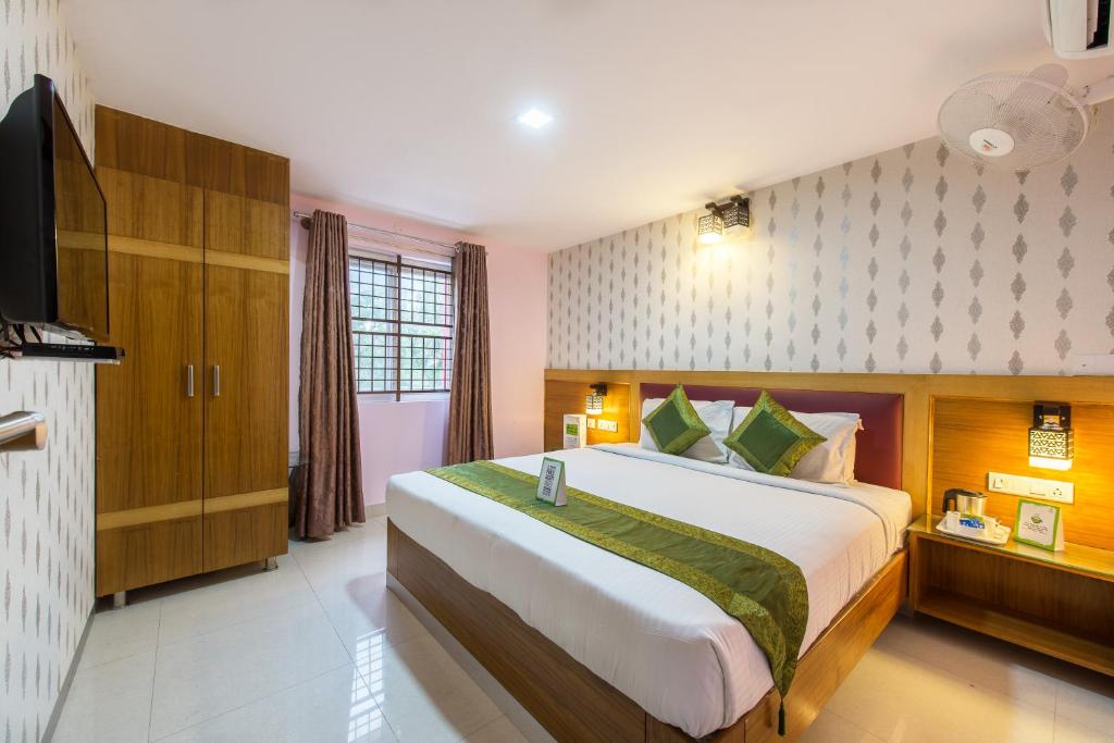 a bedroom with a large bed and a television at Treebo Trend Akshaya Lalbagh Inn in Bangalore