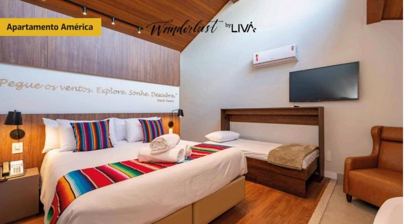 a hotel room with two beds and a tv at WANDERLUST Experience Hotel in Campos do Jordão
