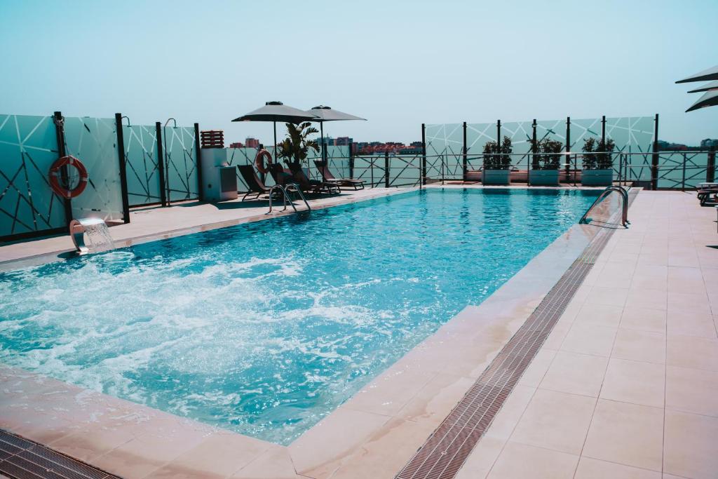a swimming pool on top of a building at Hotel Málaga Nostrum Airport in Málaga