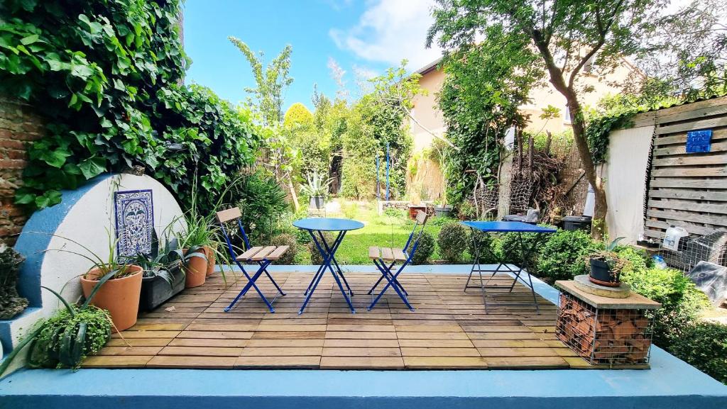 un ponte di legno con due tavoli e sedie in un cortile di COT House a Tolosa