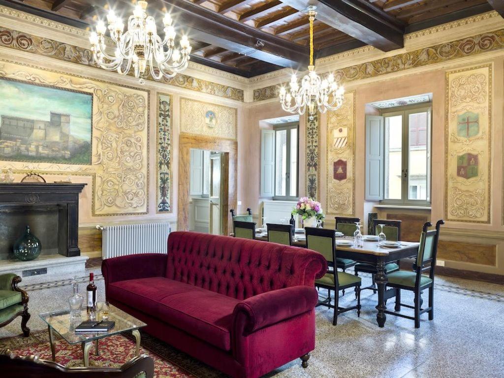 a living room with a red couch and a table at Palazzo Sapori in Soriano nel Cimino