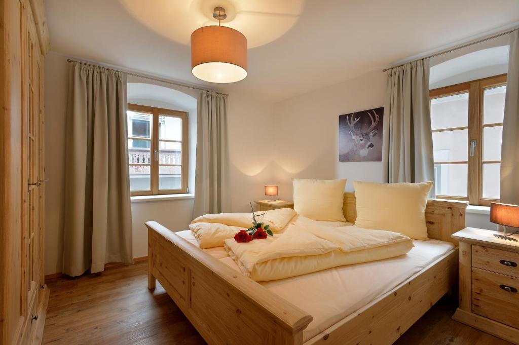 een slaapkamer met een groot houten bed met bloemen erop bij Jaegerhaus Appartements in Hopfgarten im Brixental