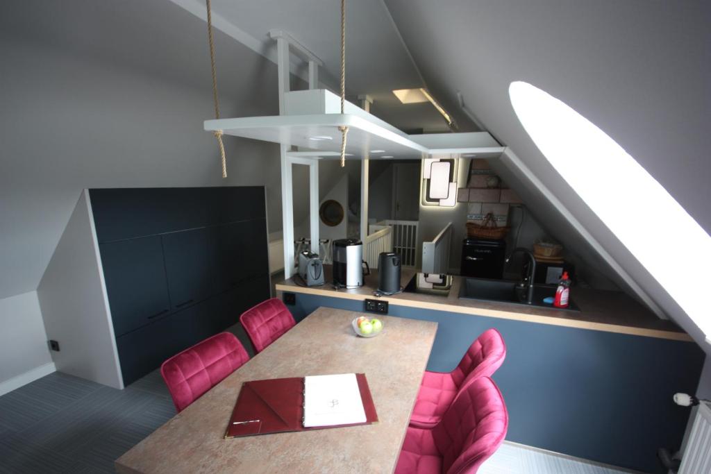 ein Esszimmer mit einem Tisch und rosa Stühlen in der Unterkunft Villa Luba in Ostseebad Koserow