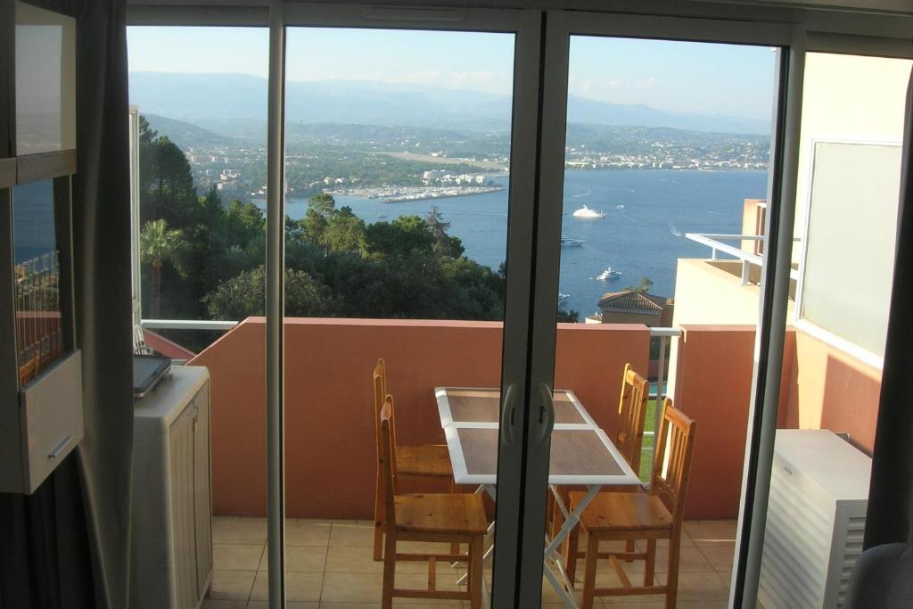 d'un balcon avec une table et une vue sur l'eau. dans l'établissement Renovated apartment in quiet residence, à Théoule-sur-Mer