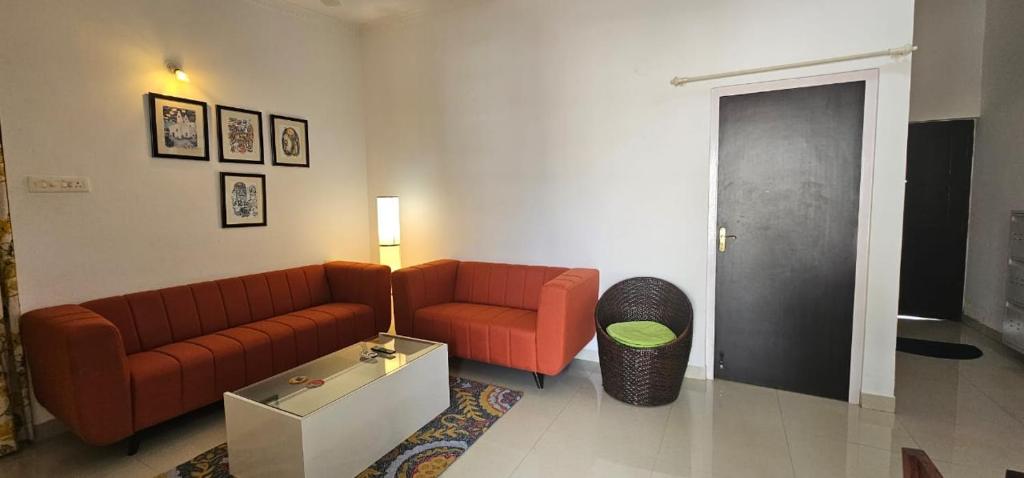 un soggiorno con un divano e un tavolo di Retreat to a stylish apartment a Candolim