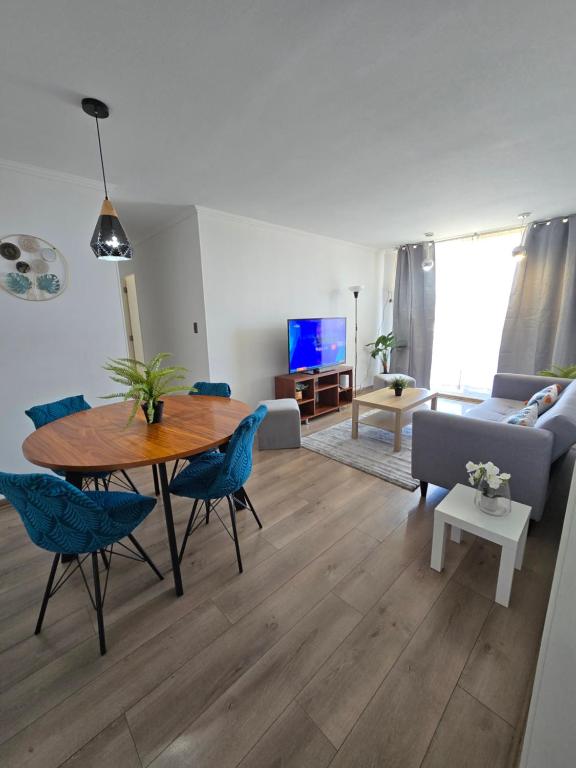 a living room with a table and blue chairs at Departamento Premium Full equipado in Rancagua