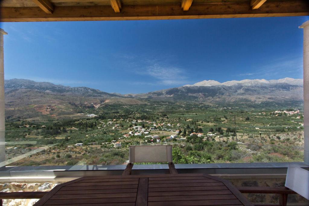 a chair sitting on a balcony with a view of mountains at Villa Galanis in Kalamitsi Amygdali