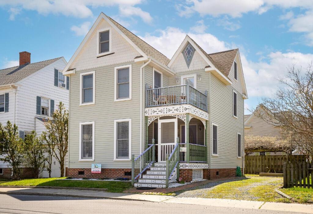 una grande casa bianca con balcone di Victorian Cottage a Chincoteague