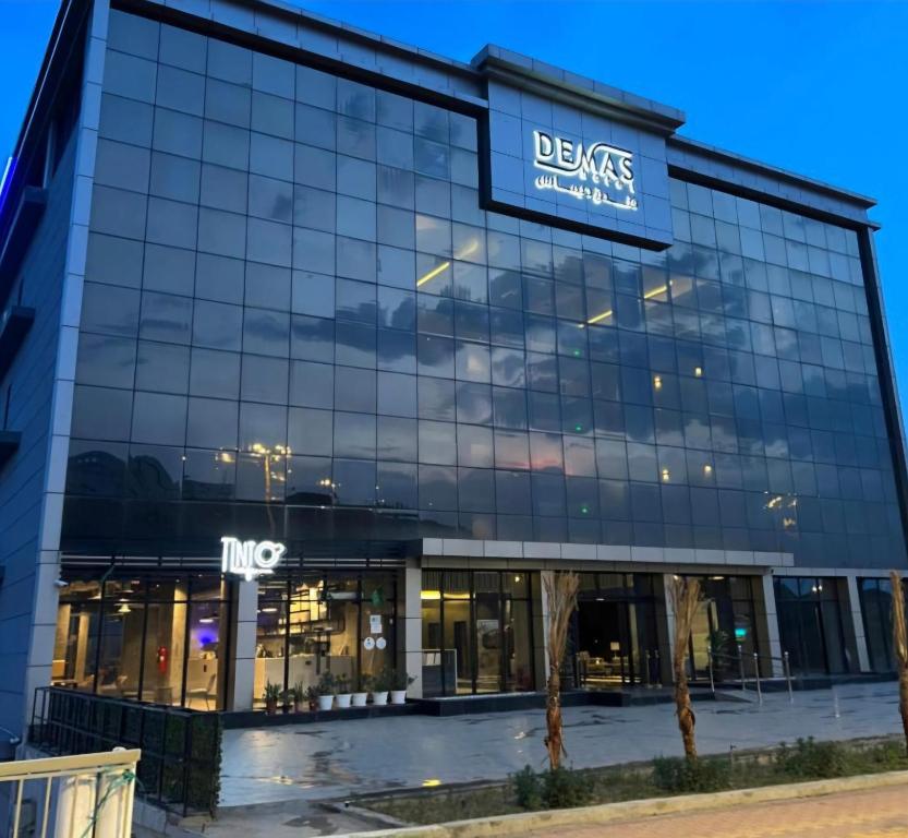 a large glass building with a sign on it at فندق ديماس DEMAS Hotel in Khamis Mushayt