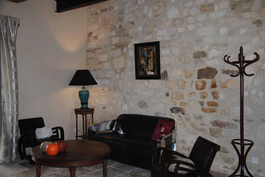 ein Wohnzimmer mit einem Ledersofa und einem Tisch in der Unterkunft Le Mas de Lucas in Arles