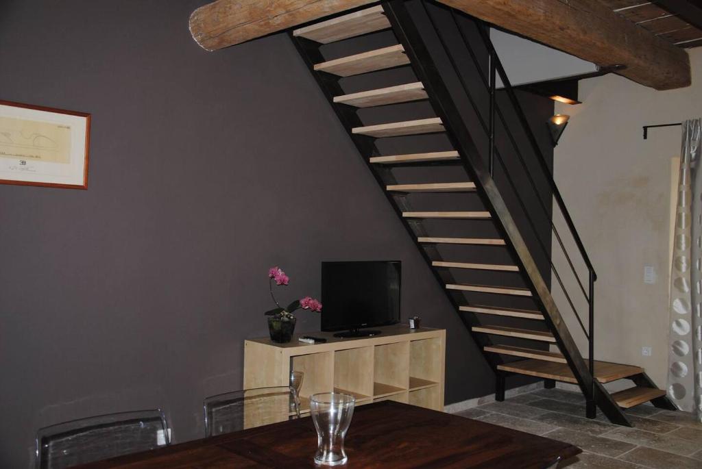 eine Treppe in einem Zimmer mit einem Tisch und einem TV in der Unterkunft Le Mas de Lucas in Arles