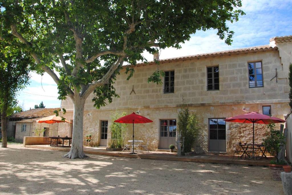 ein Gebäude mit zwei roten Regenschirmen davor in der Unterkunft Le Mas de Lucas in Arles