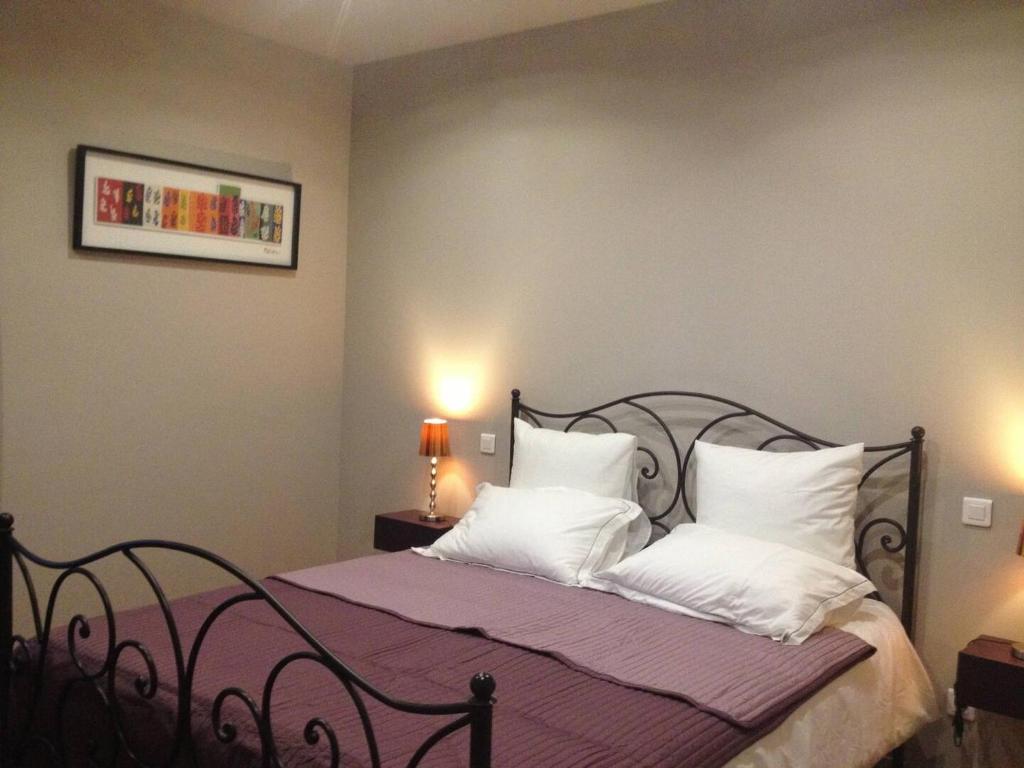 ein Schlafzimmer mit einem Bett mit weißen Kissen in der Unterkunft Le Mas de Lucas in Arles