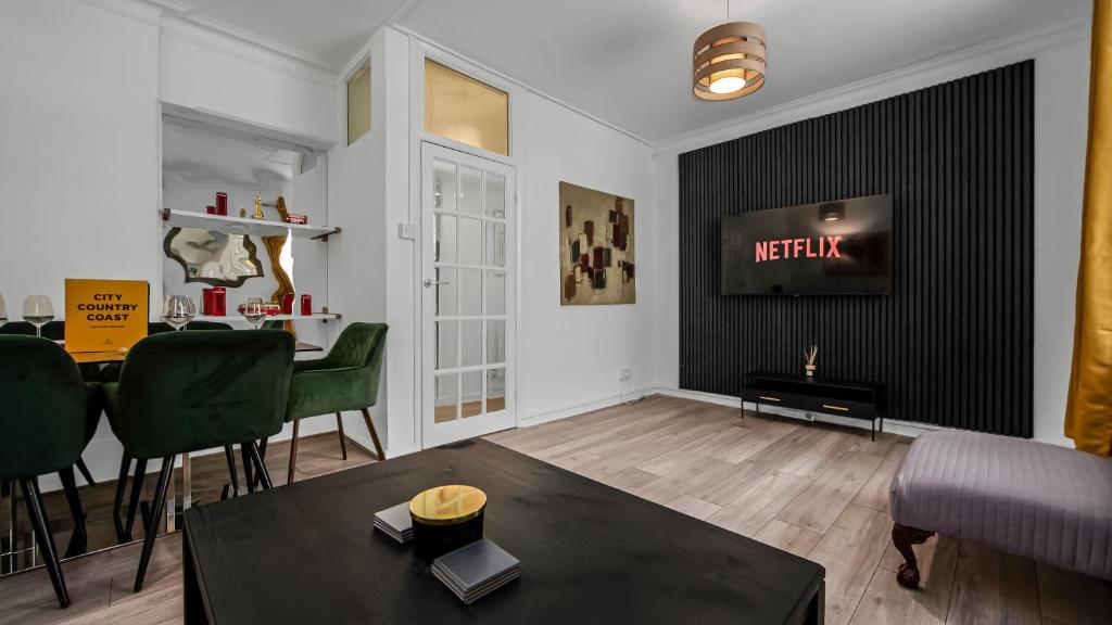 a living room with a table and a tv on a wall at Elegant Escape in Covent Garden in London