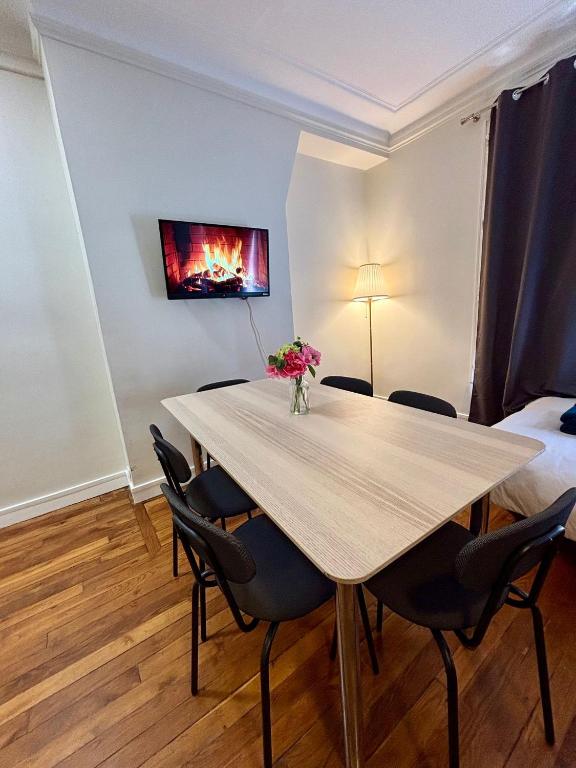 une salle à manger avec une table et des chaises ainsi qu'une peinture murale. dans l'établissement Appartement Commerce Tour Eiffel, à Paris