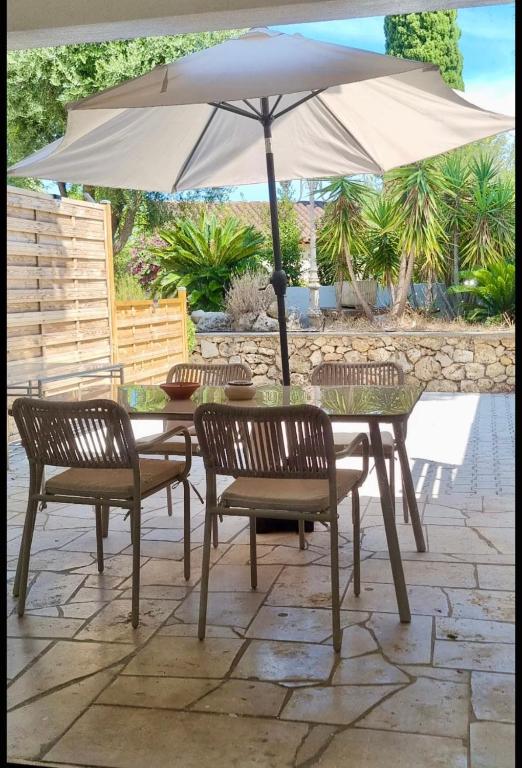 une table et des chaises avec un parasol sur une terrasse dans l'établissement Les Studios Famandiers, à Saint-Raphaël