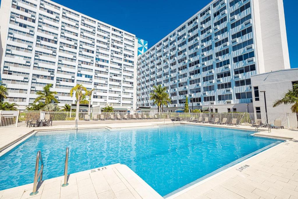 a swimming pool in front of two tall buildings at Landing Apartments - St Petersburg in St Petersburg
