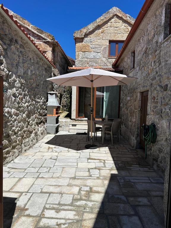 a patio with an umbrella in a stone building at Casa de Lamalonga T1 in Campos