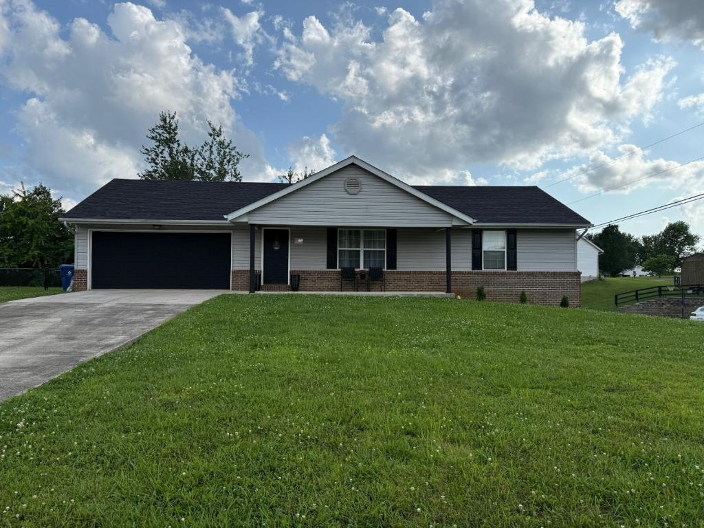 a house with a large lawn in front of it at The Nest at Lake Cumberland in Somerset