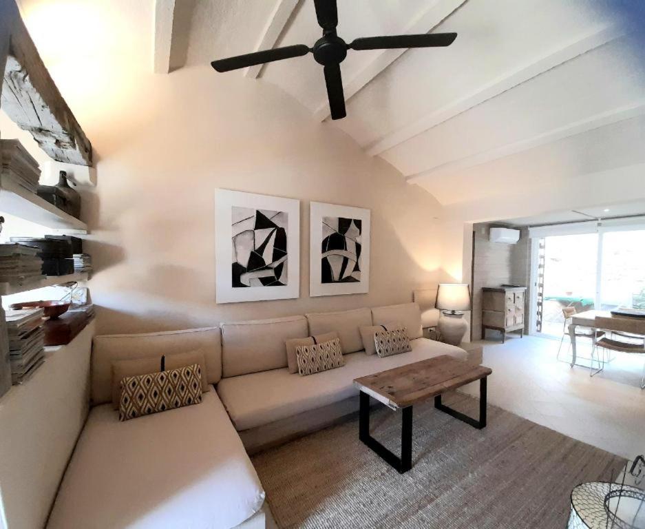 ein Wohnzimmer mit einer Couch und einem Deckenventilator in der Unterkunft Casa Marinera en El Rompido in El Rompido