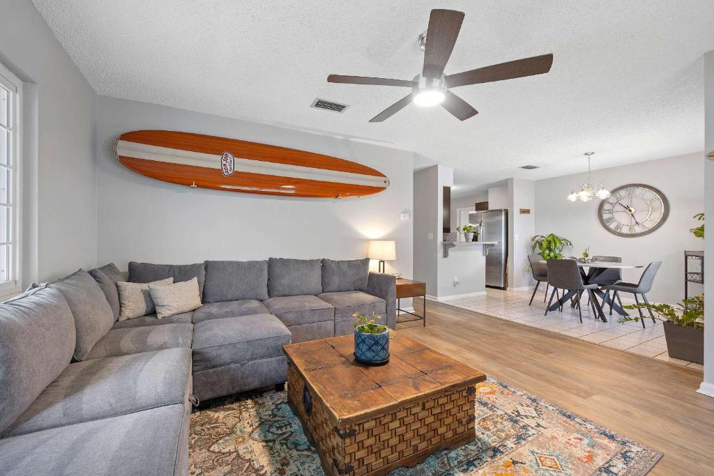 a living room with a couch and a surfboard on the wall at Casa Playa - Private Home for 6 in St. Augustine