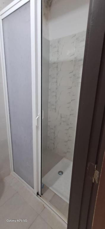 a shower with a glass door in a bathroom at Golf msnana in Tangier