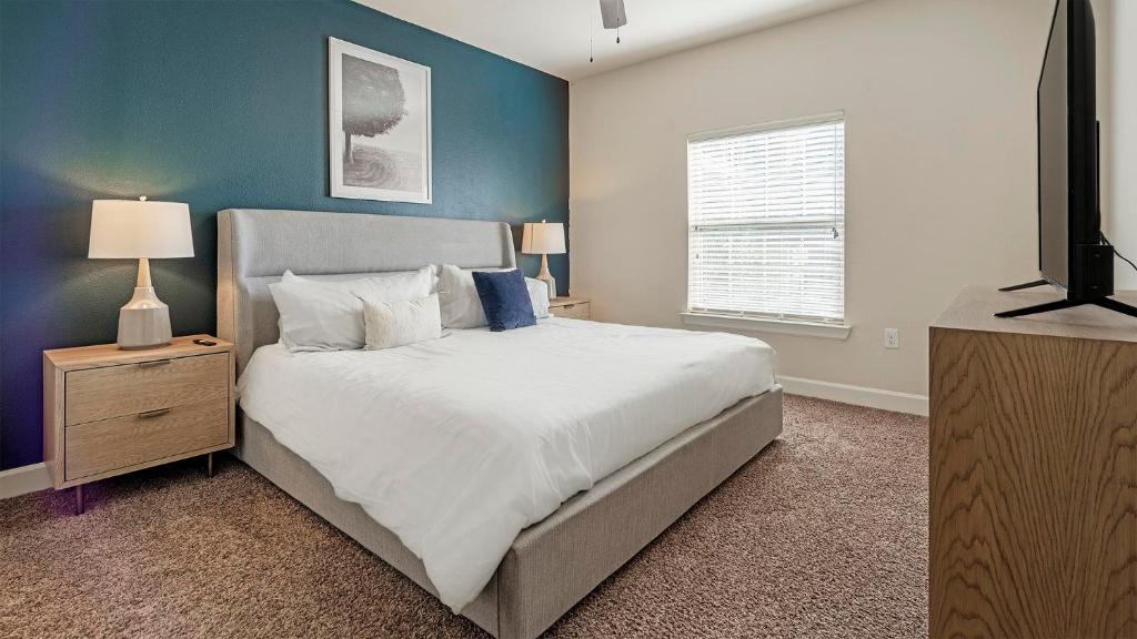 Un dormitorio con una cama y un televisor. en Landing at Mission Hill - New Braunfels, en New Braunfels