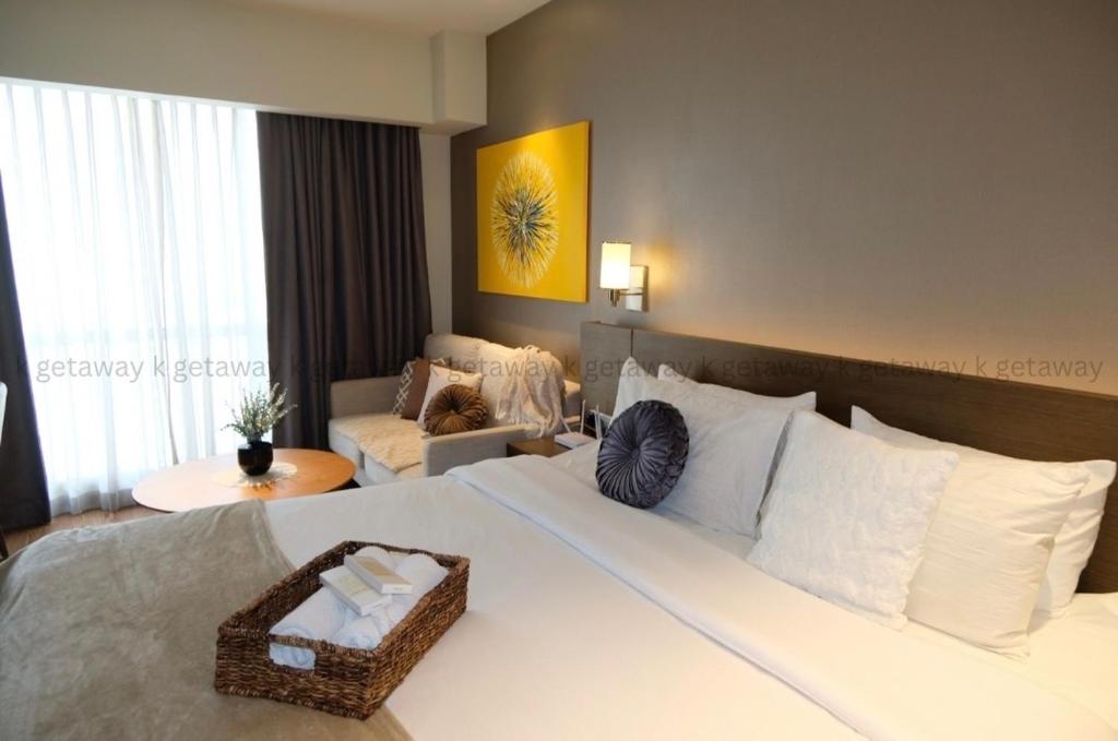 a hotel room with a bed with a basket on it at Acqua at The Hotel Residences Acqua Manila near Makati and BGC in Manila