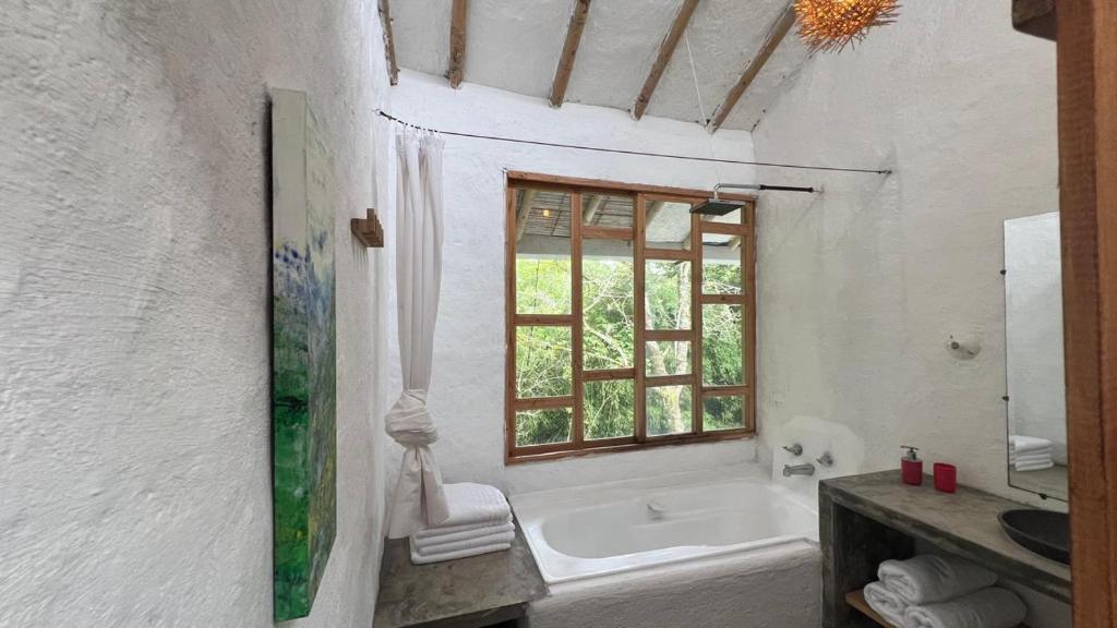 a white bathroom with a tub and a window at Casa Atamari in Salento