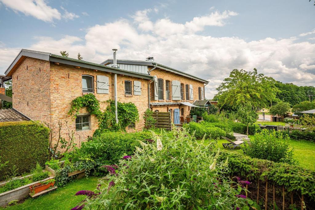a brick house with a garden in front of it at Das Backsteinhus, App Achterland in Dargen