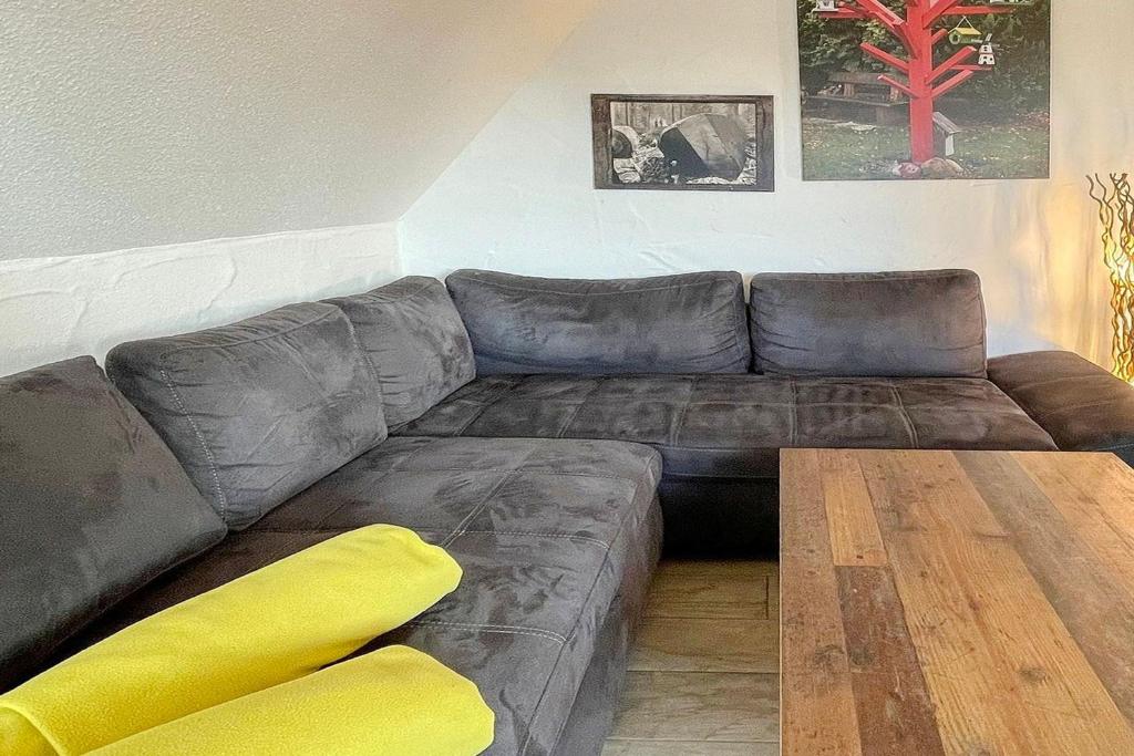 a brown couch in a living room with a wooden table at Luftschloss Baum 6 in Burg