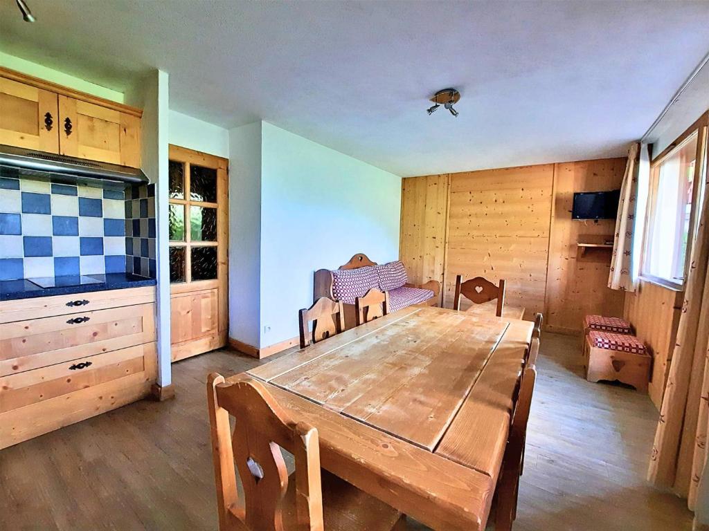 a dining room with a wooden table and chairs at Appartement cosy, 6 pers., pieds des pistes, 2 chambres, balcon sud-ouest, quartier Reberty 1850 - FR-1-452-16 in Les Menuires