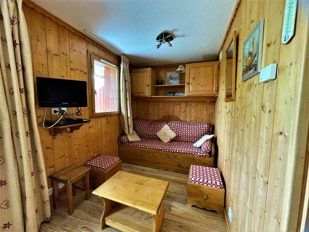- un salon avec un canapé et une télévision dans une cabine dans l'établissement Appartement cosy 4 pers. aux Menuires, proche pistes et services - FR-1-452-116, aux Menuires