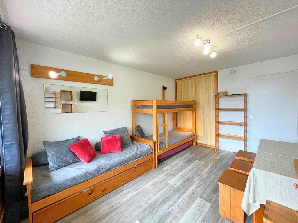 Cette chambre comprend un canapé et des lits superposés. dans l'établissement Studio pour 4 personnes avec balcon Sud, au pied des pistes, centre des Menuires - FR-1-452-99, aux Menuires