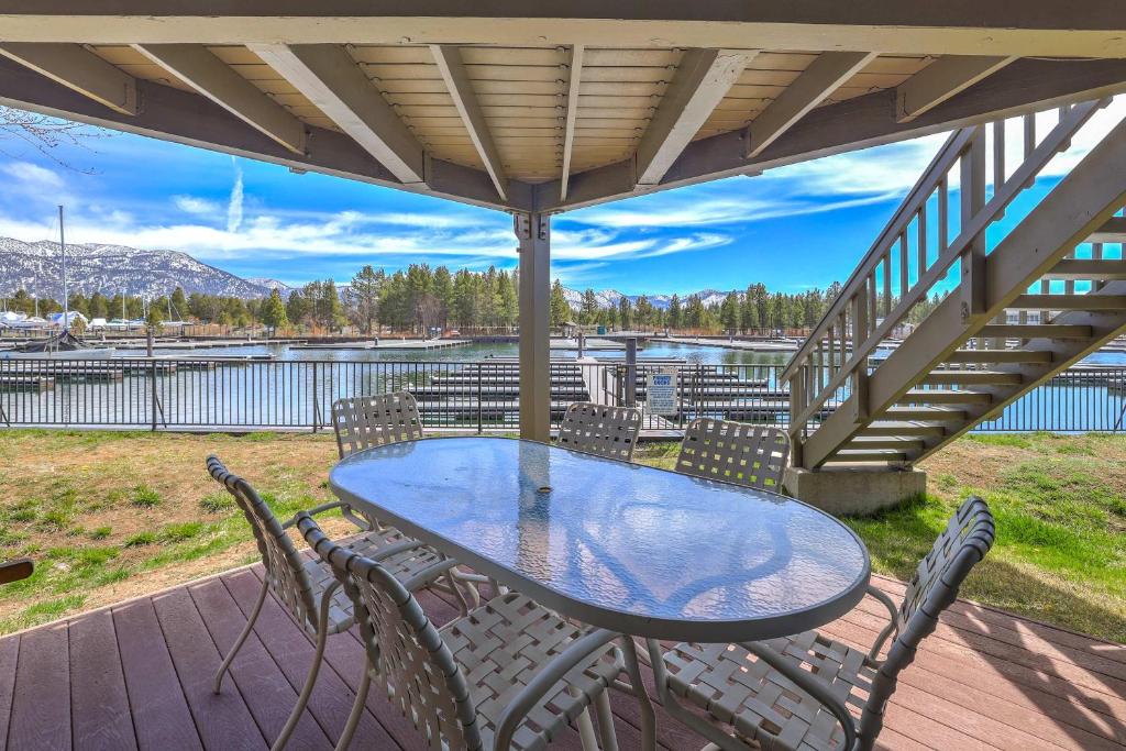 a table and chairs on a deck with a view of a lake at Tahoe Keys Marina View - 3 BDR Desirable Community in South Lake Tahoe
