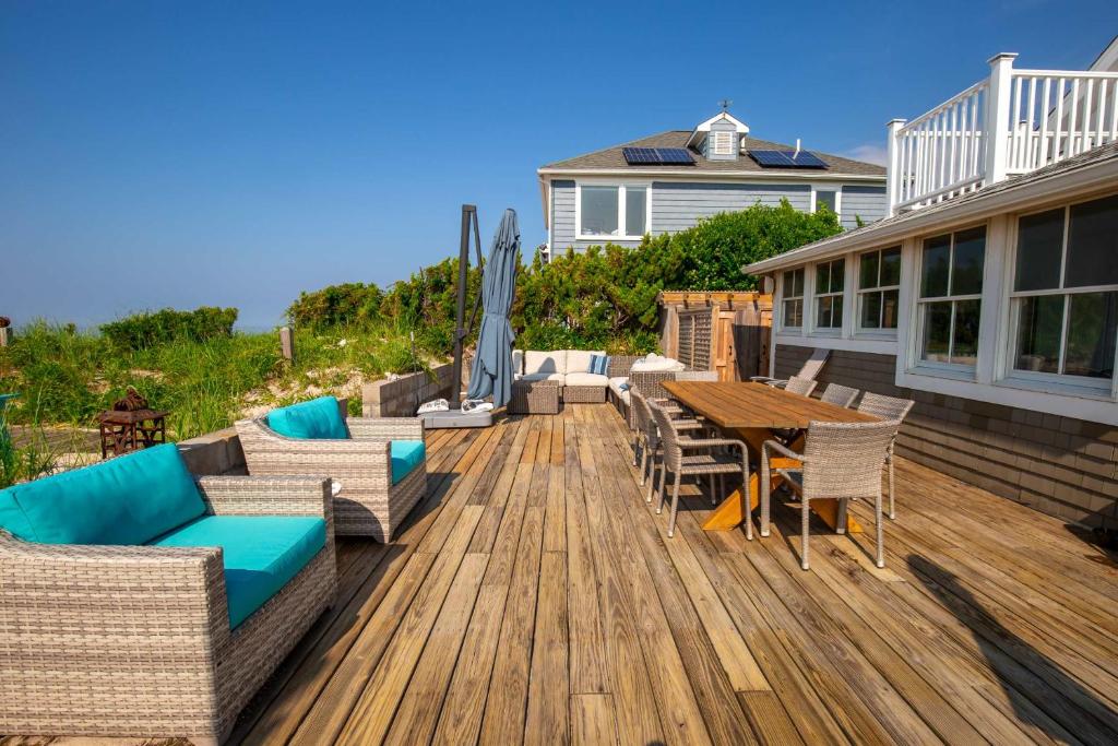 a wooden deck with a table and chairs on a house at Diana Luxury Retreat: Private Beach and Vineyards in Wading River