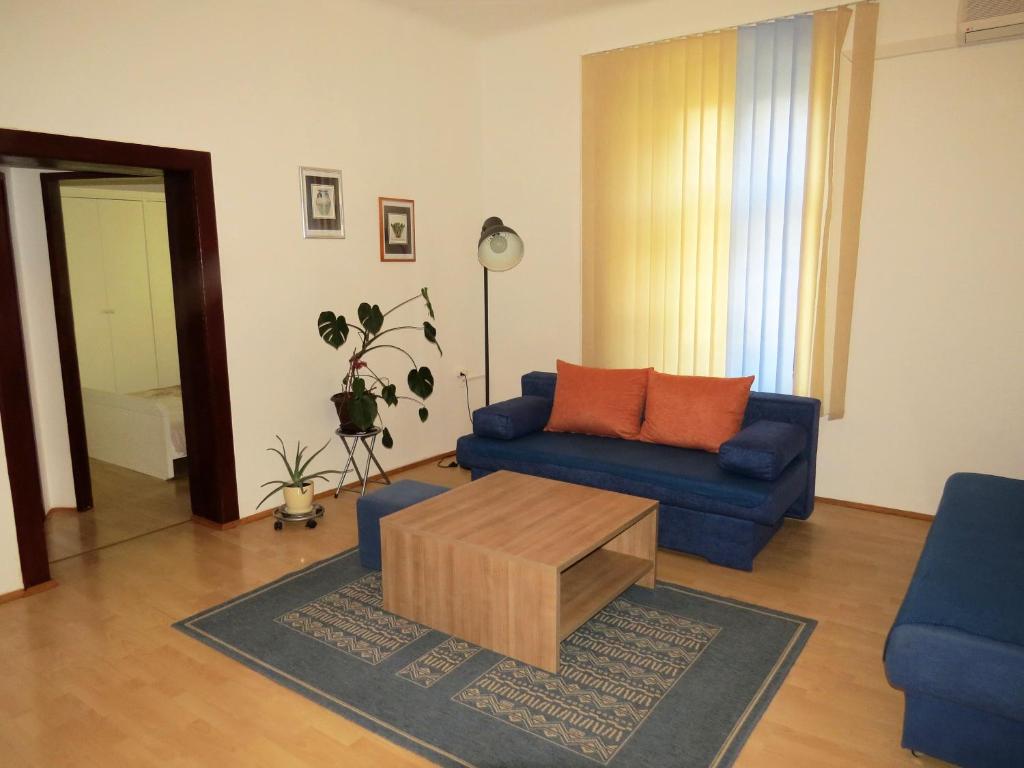 a living room with a blue couch and a coffee table at Apartment Stoja in Pula