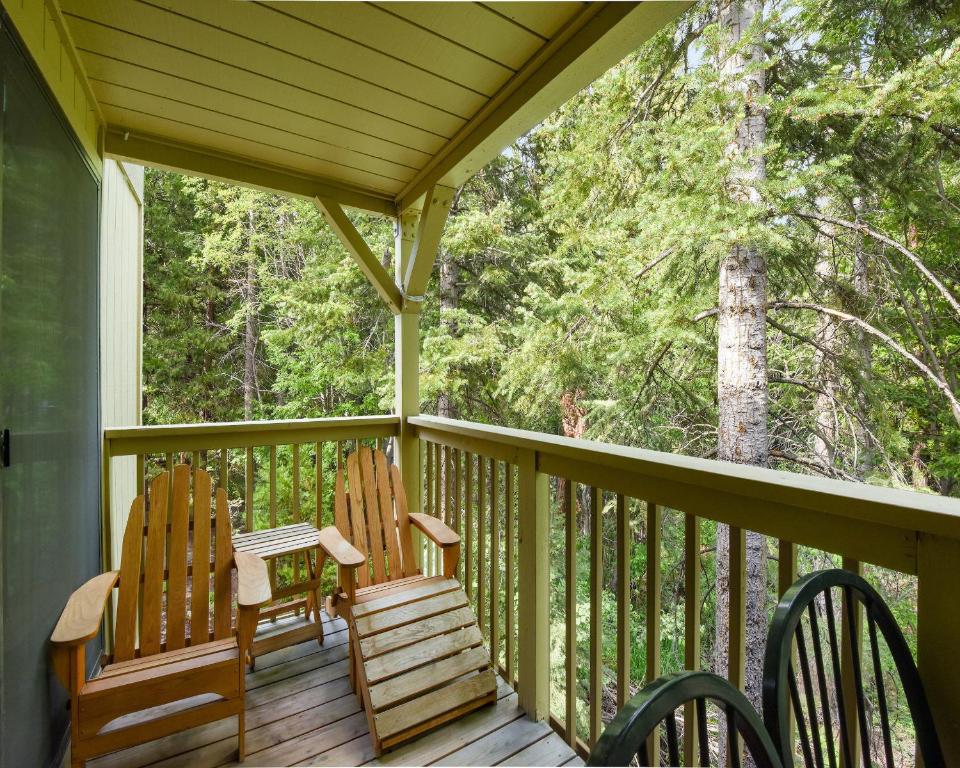 two rocking chairs sitting on a porch with trees at Enjoy Forest Views Retreat at Kingswood Village in Kings Beach