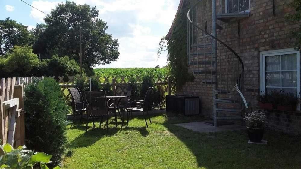 a patio with a table and chairs in a yard at Ferienwohnung Tegge in Welzin